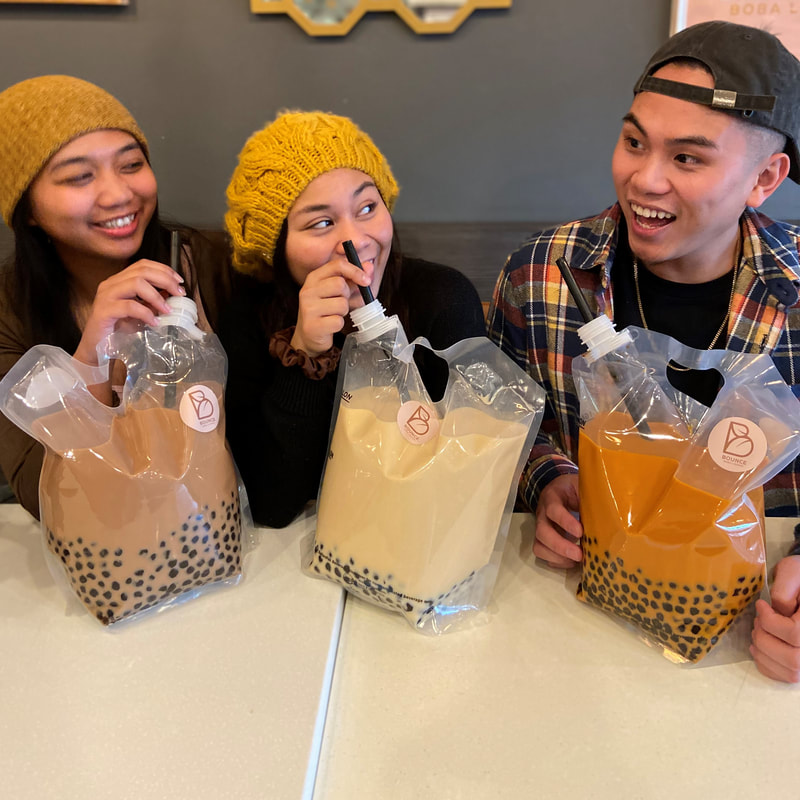 Friends holding Bounce Boba Lounge party packs